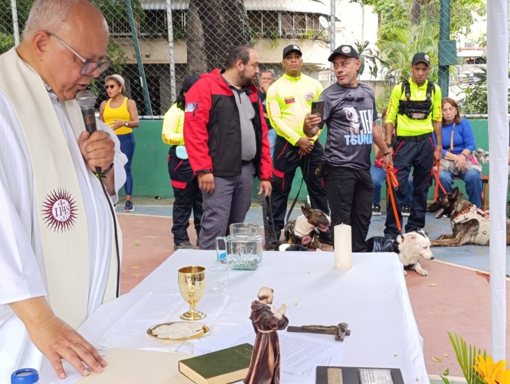 Padre Alex Salom durante Misa de Bendición de Mascotas en APROA, junto a Tsunami y Jorge Beens y otros binomios rescatistas